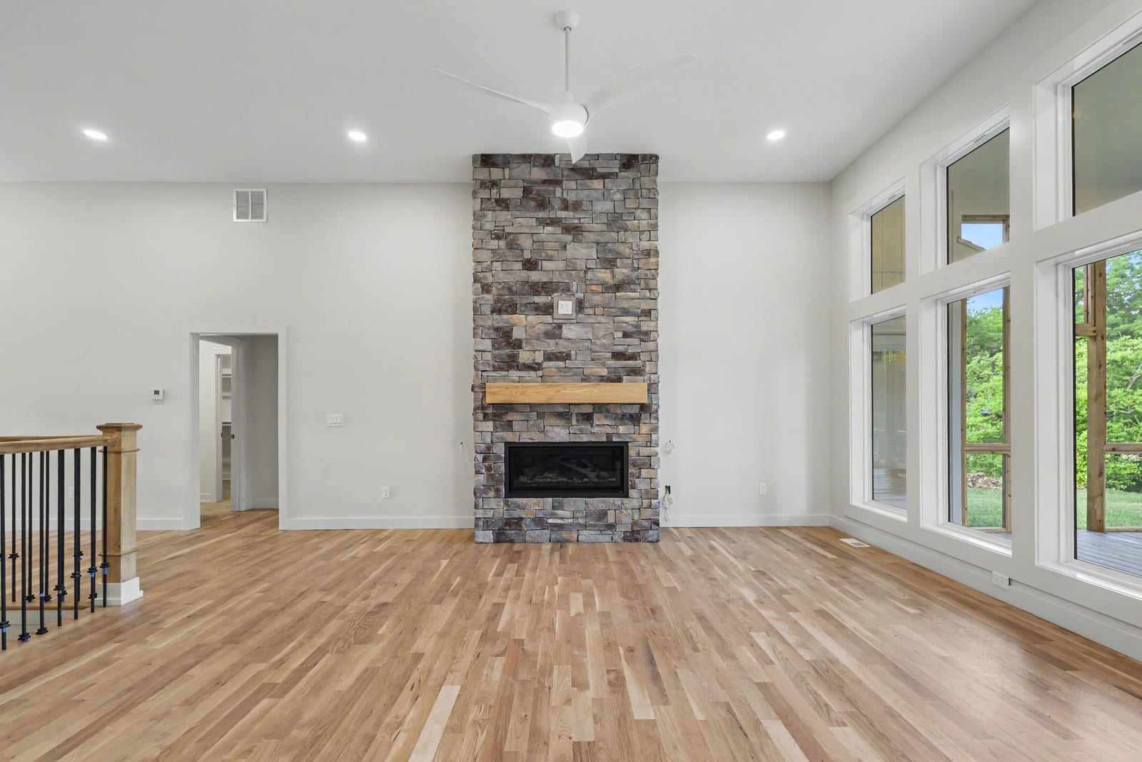 Floor-to-ceiling windows beside the stone fireplace